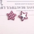 Detail shot of pink plaid star buttons, DIY craft fabric patches, close-up accessories view. - Pink