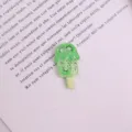 Close-up detail of cute kiwi popsicle resin flatback charm for DIY craft and shoe decoration. - Kiwi
