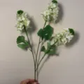 Dettaglio di ramo di fiore di delphinium bianco artificiale con petali e foglie verdi. - Giacinto