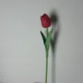 Detaillierte Nahaufnahme einer künstlichen roten Tulpe mit realistischem grünem Stiel und Blättern. - Rote Tulpe