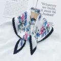 Pleated floral scarf detail, elegant white neckerchief with blue pink flowers and black trim. - Black Edge
