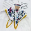 Detailed view of pleated floral scarf with vibrant blue pink pattern and yellow border accents. - Turmeric Edge