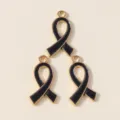 Detail shot of black enamel ribbon alloy charms, gold trim bow pendants for DIY jewelry making. - Black