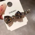 Detailed view of the luxury crystal bow hair clip featuring sparkling rhinestones. - Heavy Rhinestone Bow Hairpin / Gunmetal