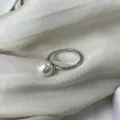 Detalle de cerca de anillo de perla abierto plateado minimalista accesorio de joyería. - Abierto Ajustable / Blanco