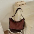 Bruine suède schoudertas voor dames, vintage casual crossbody messenger tas met klepzakken. - Met Hanger / Roodbruin