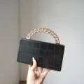 Elegant black crocodile embossed structured box handbag with chic gold chain handle detail. - Black