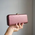 Metallic clutch evening bag detail view, showcasing exquisite texture and elegant metal clasp. - Burgundy
