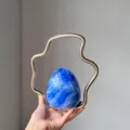 Detailed view of the luxury marble blue egg evening bag with unique gold wavy metal handle. - Fluid Blue