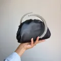 Elegant black satin pleated evening clutch bag featuring a stunning crystal crescent handle. - Black