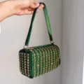 Green rhinestone studded handbag detail showing the sparkling crystals and metallic hardware. - Green
