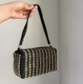 Close-up view of the luxury black rhinestone evening box bag with shining gold geometric rings. - Black