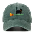 Close-up detail of the black cat witch embroidery on the vintage washed green baseball cap. - One Size / Grass Green