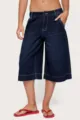 Detailed shot of dark blue denim capri pants, featuring relaxed wide-leg cut and contrast stitching. - S / Bottoms / Black Blue