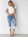 Detailed view of women cropped denim jeans with delicate white lace cuffs, stylish and casual. - S / Bottoms / Light Blue