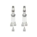 Close-up detail of ethnic style silver long tassel earrings with decorative metal bells. - White