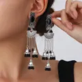 Detailed view of bohemian vintage silver long tassel earrings with black stones and bell charms. - Fan Carved Tassel Bell Style (S5121-5)