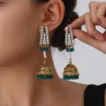 Vintage gold-tone jhumka earrings featuring sparkling rhinestones, pearls and green bead tassels. - Green