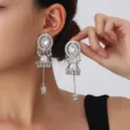 Close-up of ethnic silver jhumka earrings featuring hollow disc and crystal stones. - Bell Tassel Drop Earrings / Silver (S5111-3)