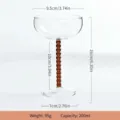 Klares Glas Cocktail-Champagner-Glas mit bernsteinfarbenen Perlenstiel, elegante Vintage-Variante. - Braun
