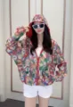 Detailed close-up view of the women's colorful floral print sun protection hooded jacket. - M / Tops / Colorful Print (Red Edging)