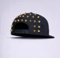 Casquette de baseball noire avec clous métalliques coniques dorés et fermeture réglable à l'arrière. - Casquette à Rivets Dorés Inversés