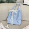 Light blue striped fabric tote bag featuring a delicate white lace bow and charming star patterns. - Dark Blue With White Flower Bow