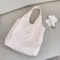Detailed shot of pink striped canvas tote bag with silver stars and cozy lifestyle props. - Pink