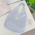 Detail of the fresh blue striped tote bag featuring cute star patterns for daily use. - Light Blue
