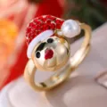Detalle del anillo abierto de muñeco de nieve navideño con pedrería roja y perla. - Abierto ajustable / Dorado