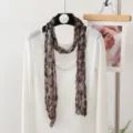 Detailansicht des schmalen, geknitterten Leoparden-Musterschals für stilvolle Herbst-Outfits. - 180x20cm / Großer Leopard Kaffee