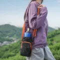 Outdoor sports shoulder mobile phone bag detail shot, featuring durable fabric and orange strap. - Orange
