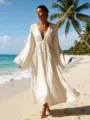 Vista detallada de un vestido largo elegante de manga larga con cuello en V en la playa. - S / Vestidos / Blanco