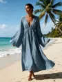 Detailansicht des eleganten V-Ausschnitt Maxikleides mit langen Ärmeln an Strandkulisse. - Dunstblau