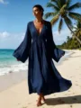 Detailansicht des dunkelblauen Maxikleids mit V-Ausschnitt und langen Aermeln am Strand. - Marineblau