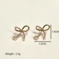 Elegant gold bowknot stud earrings featuring sparkling zircon and delicate pearl cluster accents. - Bow