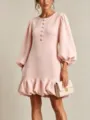 Close-up detail of light pink dress featuring floral buttons and voluminous lantern sleeves. - Pink
