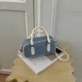 Chic denim quilted pillow handbag with white handles, versatile crossbody bag for daily use. - White