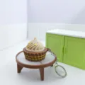 Nahaufnahme eines 3D-gedruckten Miniatur-Cupcake-Design-Klicker-Schlüsselanhängers. - Beiger Keks