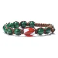 Close-up detail of handmade woven bracelet with green beads and central red dzi bead. - Green Sesame