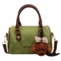 Retro green suede Boston crossbody bag featuring cute plush puppy charm and brown leather handles. - Green