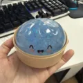 Detailaufnahme des blauen Glitzer Knautschball Brötchen Spielzeugs in einem kleinen Dampfgarer Korb. - Hellblau