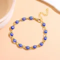 Gold-plated evil eye charm bracelet with blue glass beads and adjustable extension chain. - Blue and Gold
