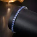 Detailed close-up shot of a sparkling blue zirconia tennis bracelet on a dark display stand. - Blue Zircon