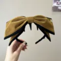 Vue détaillée du grand serre-tête nœud en velours rétro, design marron et noir élégant. - Serre-tête Grand Nœud Peigne à Dents / Jaune