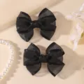 Nahaufnahme der schwarzen Organza Doppelschleife Haarklammern mit feiner Textur und Stil. - 2 Stück/Packung / Schwarz