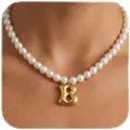 Primer plano detallado del collar de perlas con un colgante de letra B dorada chic. - Letra B