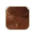 Primer plano de un elegante collar doble de oro adornado con un delicado colgante de media luna. - Letra C