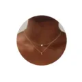 Primer plano detallado del collar dorado de doble capa minimalista con colgante y letra L. - Letra L