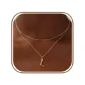 Gedetailleerde close-up van het elegante dubbele gouden letter L hanger halsketting ontwerp. - L